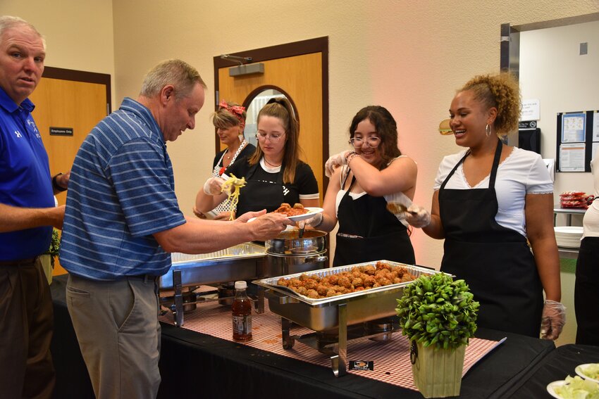 Fort Lupton Jim Roedel Weld Re-8 Schools Chief Operator Office, and David Muniz being served dinner by Fort Lupton High School students  Laniea Harris, Elena Sanchez, and Skye Thyfault.